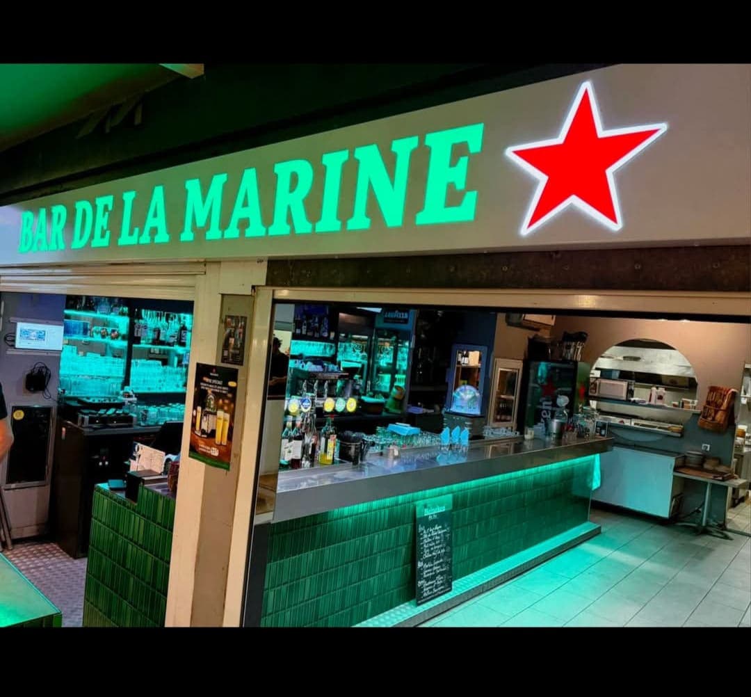 La façade du Bar de la Marine et son enseigne lumineuse verte, au-dessus du comptoir carrelé